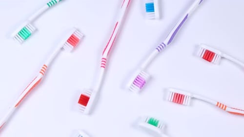 Background Dental Toothbrushes of Different Colors on a White Background Top View