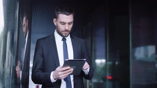 Businessman Using Tablet Device Outdoors in Urban Setting