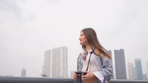 Asian woman traveler use camera taking a photo while traveling in city.