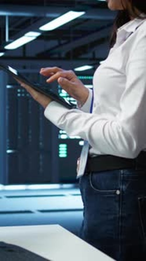 Woman Uses Tablet in Futuristic Server Room