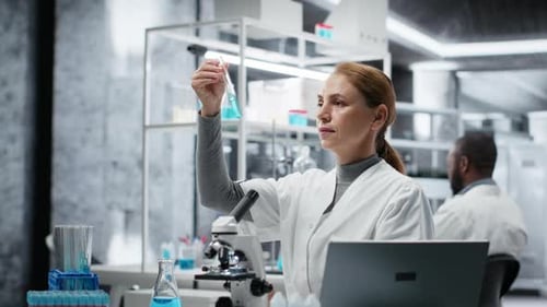 Scientist in Lab Pipetting Blue Liquid Into Test Tube to Analyze It