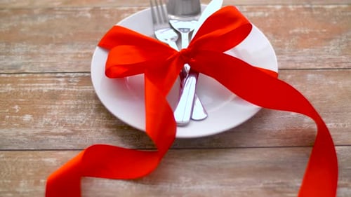 Festive place setting with ribbon, plate, cutlery