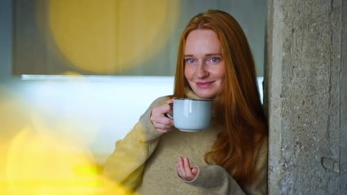 Redhead Woman Drinking Coffee in Cozy Setting