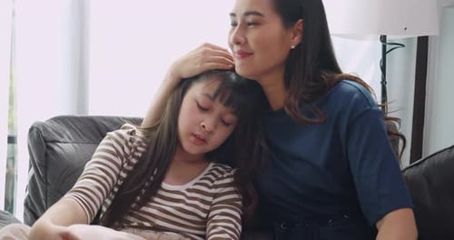 Adult Comforting Sad Child on Couch