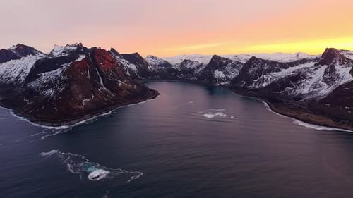 Aerial view of a stunning sunset over a fjord in Norway, surrounded by mountains