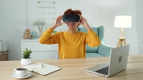 Young Woman Using VR Headset at Desk