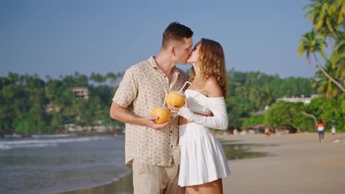 Happy Couple Kissing on the Sandy Ocean Shore Young Woman Man Hugging and Smiling on Stroll at