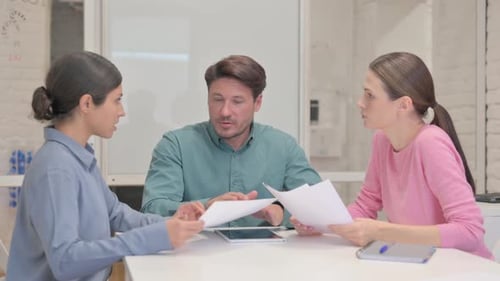 Middle Aged Man Guiding Multi Ethnic Employee in Office