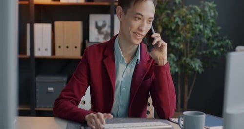 Young Adult Talking on Smartphone in Modern Office