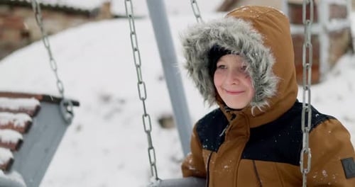 Child on Swing in Winter Snowfall