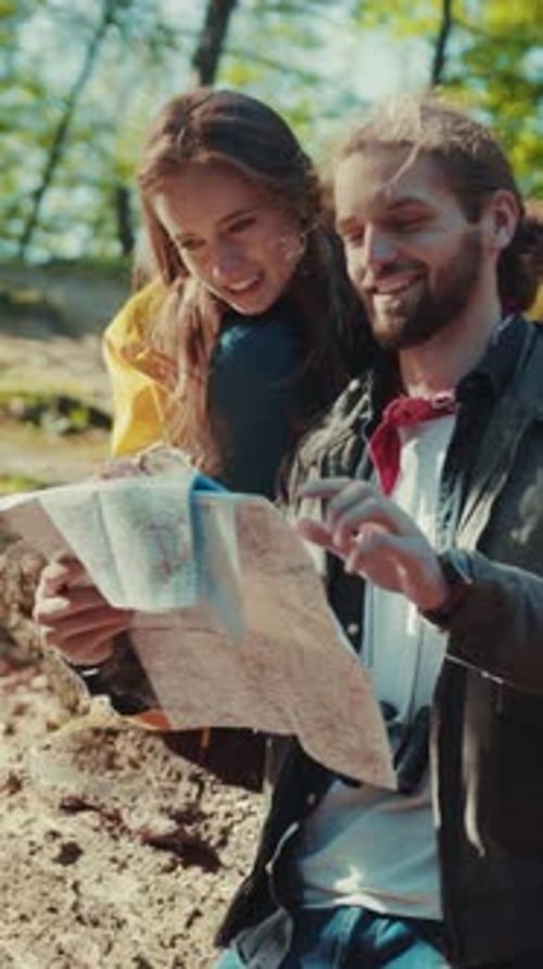 Couple Exploring with Map in Sunny Forest