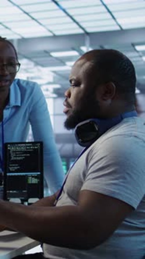 Two Adults Collaborating on Code in Modern Office