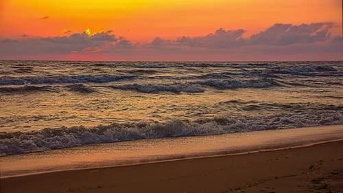 Orange sunset timelapse seaside beach, with tide waves motion, scenic view
