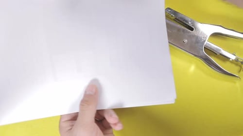 Hands Stapling White Papers with Metal Stapler