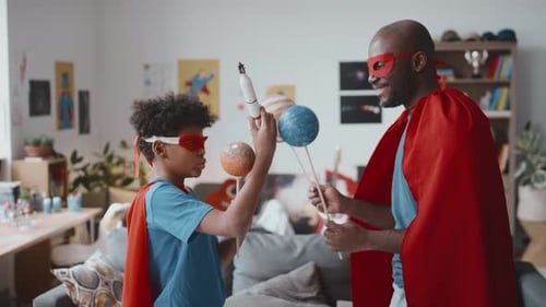 Dad and Son Playing Superheroes with Planets