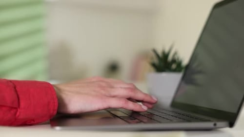 Woman Typing on Laptop Keyboard in Bright Room