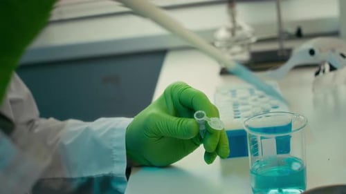 Gloved Hand Using Pipette in Scientific Laboratory Setting