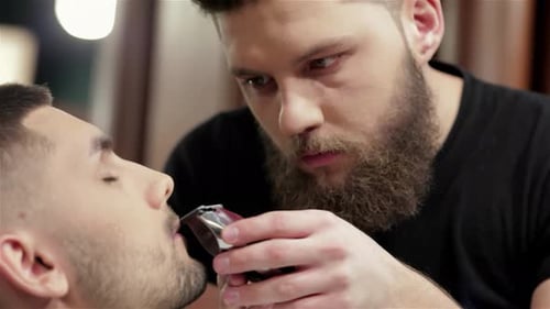 Expert Barber Skillfully Shaping a Beard at a Trendy Hair Salon
