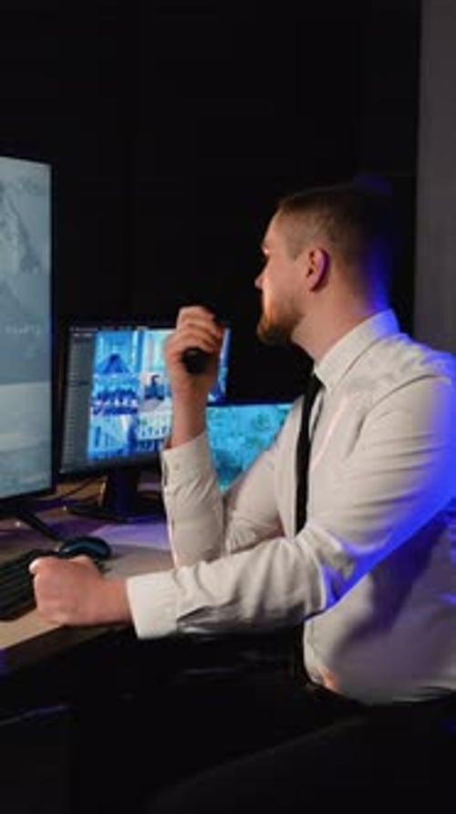 Man Working Security With Walkie Talkie and Monitors
