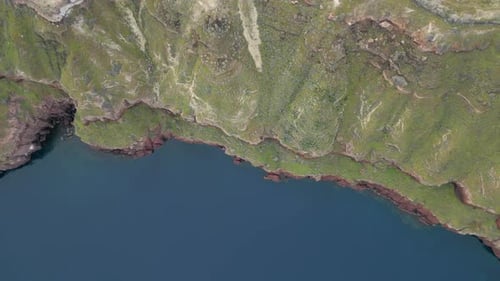 Aerial View of Santorini Coastline with Vibrant Green and Red Rocks