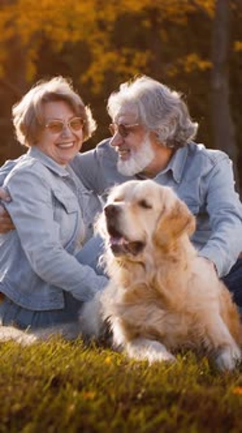 Old People Hugging and Stroking Dog in Autumn Park
