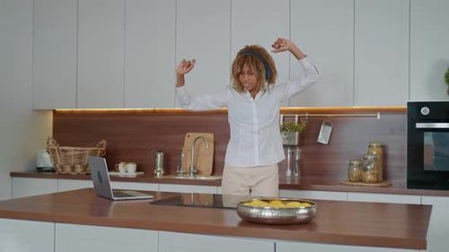 Woman Dancing in Kitchen Wearing Headphones
