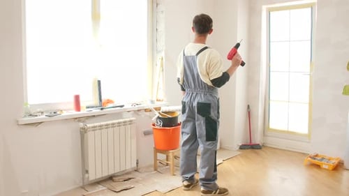 Man Holding a Drill in Renovated Room