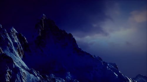 Snowy Mountain Peaks Under Twilight Sky with Dramatic Lighting Effects