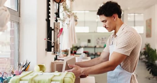 Negocios, embalaje y hombre en taller de cerámica, cajas o comercio electrónico con productos de arte
