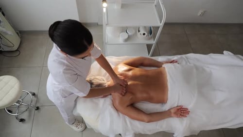 Professionelle Masseurin führt Rücken- und Nackenmassage durch