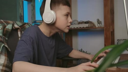 Teen Boy Plays Computer Game at Home