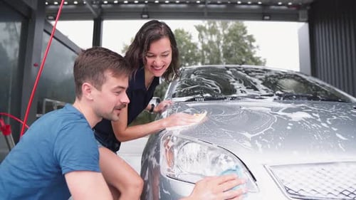 Young Couple Washing Car Together at Carwash