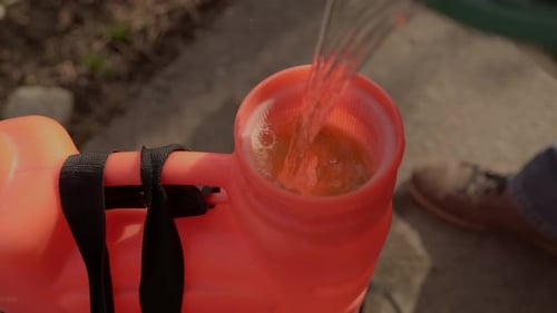 Gardener Preparing Fertilizer Solution in a Backpack Sprayer