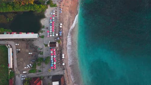 Top down view of tropical beach with colorful sun umbrellas