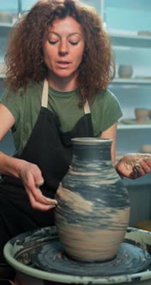 Woman Creates Beautiful Pottery on Wheel in Studio