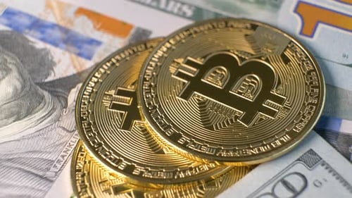 Gros plan de pièces de monnaie cryptographique Bitcoin brillantes en métal sur des billets en dollars américains