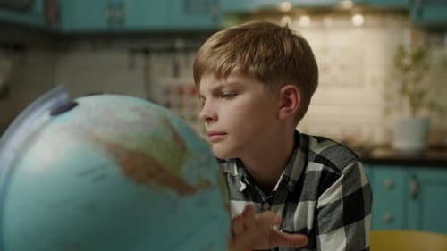Boy Looks at Globe in Kitchen