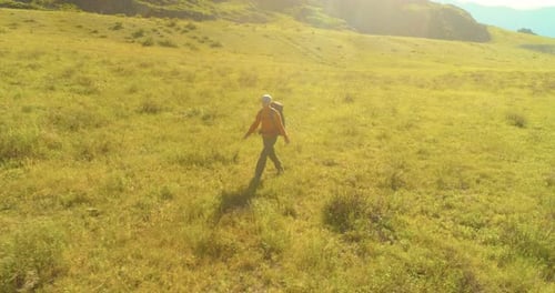 Flight Over Backpack Hiking Tourist Walking Across Green Mountain Field Huge Rural Valley at Summer