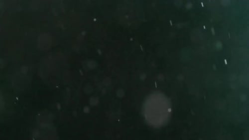 Collider Collection: Falling dust bubble effect over a black background