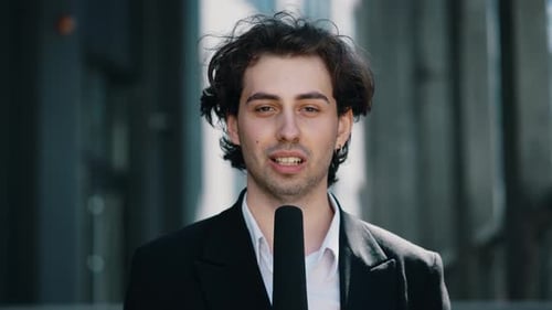 Portrait Shot of Young Caucasian Handsome Male Journalist Talking with Microphone for News Episode