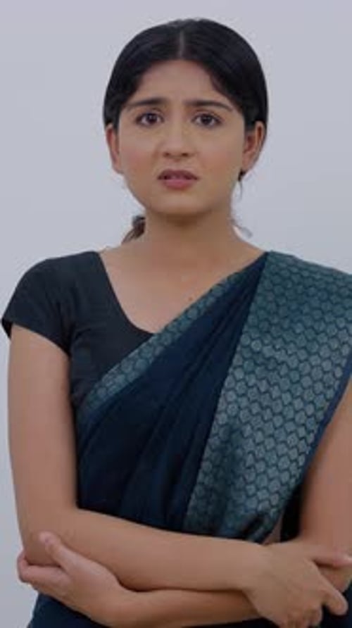 Young Woman Looking Worried and Arms Crossed Indoors