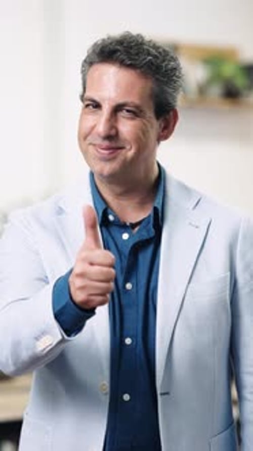 Man Gives a Thumbs Up in an Interior Setting