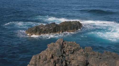Eine große Welle des Atlantiks bricht an einer Felsenküste an einem sonnigen Tag während eines Sturms in der