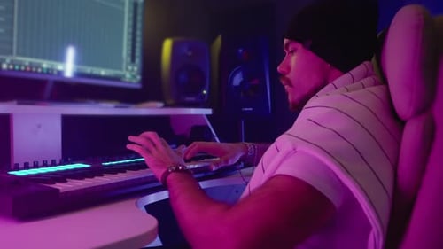 Music Maker Creating Track in Studio Using Synthesizer and Computer