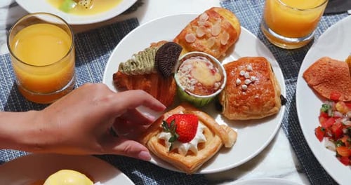 Breakfast Buffet: Woman's Hand Selects Strawberry Pastry