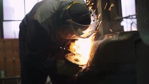 A Worker Welds in an Industrial Setting Demonstrating Key Skills and Craftsmanship Stock Clip
