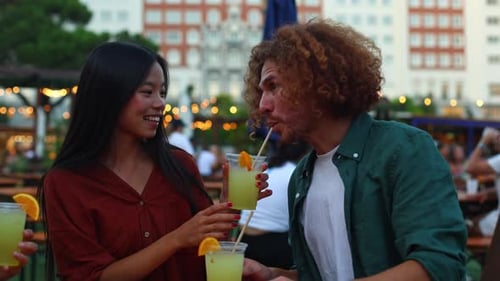 Young Adults Socializing with Drinks Outdoors in City