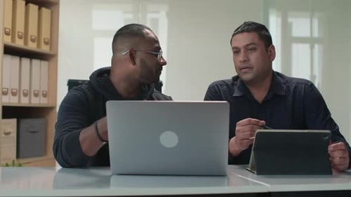 Two Men Collaborating on Tech Projects in Office