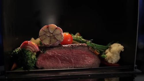 interior view of rotating cooker with meat and vegetables