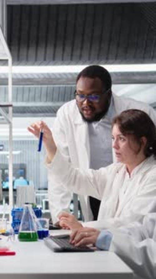 Vertical Video Multiethnic Chemical Engineers Using Laboratory Glassware with Solution